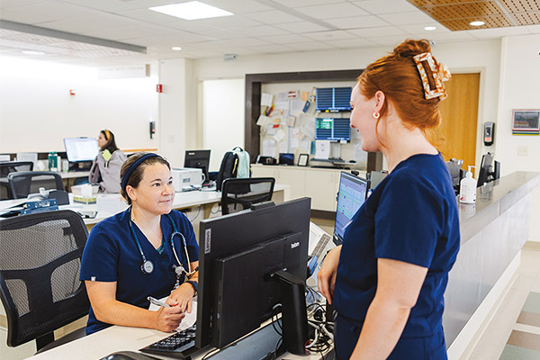 Casey Massimini, MSN, RN-CV and Kelsey Barlow, LPN prepare to hand off patient.